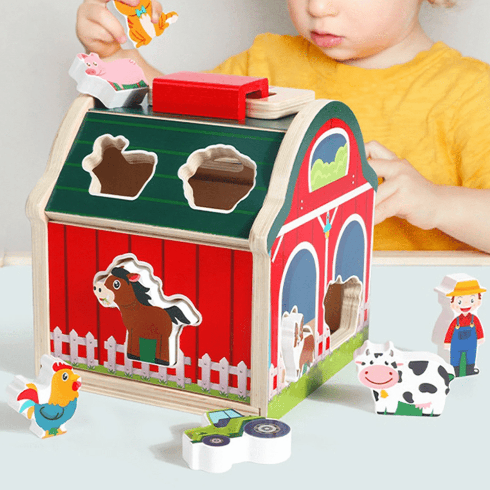 Nahaufnahme rotes Holz-Sortierhaus – Öffnungen für Ente, Pferd und Huhn